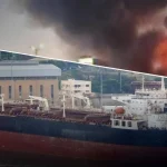 Танкер тіньового флоту РФ у порту, уражений Силами оборони України: пожежа та густий дим від удару по судну та нафтобазі.