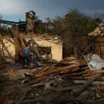 Чоловік стоїть серед уламків зруйнованої будівлі після російського удару на Київщині