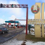 Прикордонний пункт Білорусі з великою стелою Республіка Білорусь та сірим автомобілем