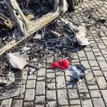 Згорілий кузов Mercedes, уламки та попіл на бруківці після вибуху