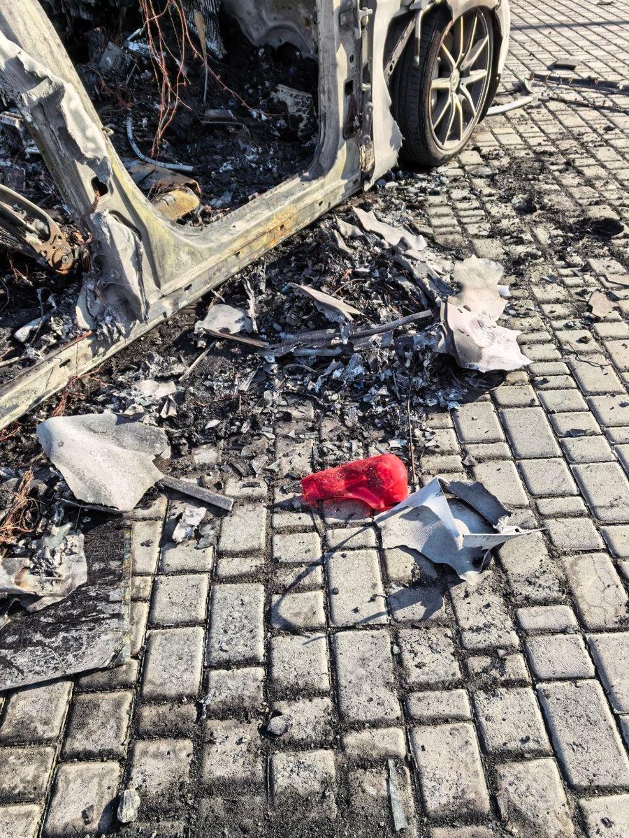 Згорілий кузов Mercedes, уламки та попіл на бруківці після вибуху