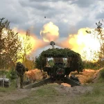 Прикордонники ведуть вогонь з камуфльованої гаубиці серед дерев