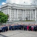 Група дипломатів у костюмах перед будівлею МЗС України