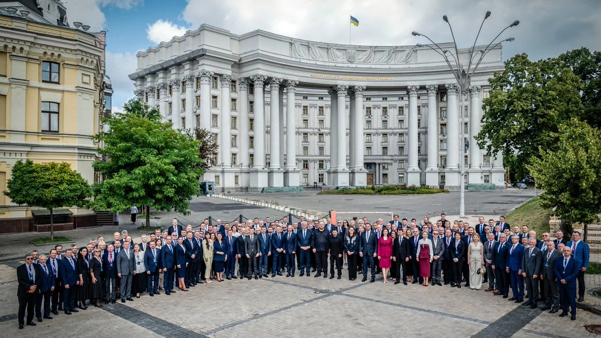 Група дипломатів у костюмах перед будівлею МЗС України